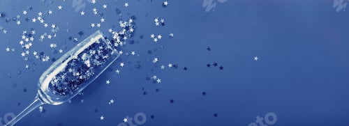 Preview: Champagne glass with star shaped sequins on a blue background