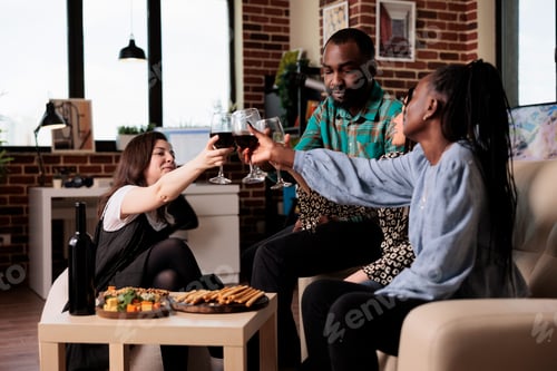 Preview: Diverse people celebrating friendship event while having wine party at home
