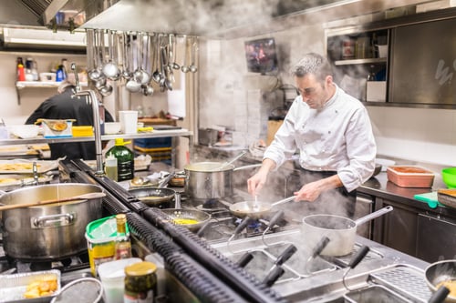 Preview: Chef cooking in a restaurant kitchen, seen through steam