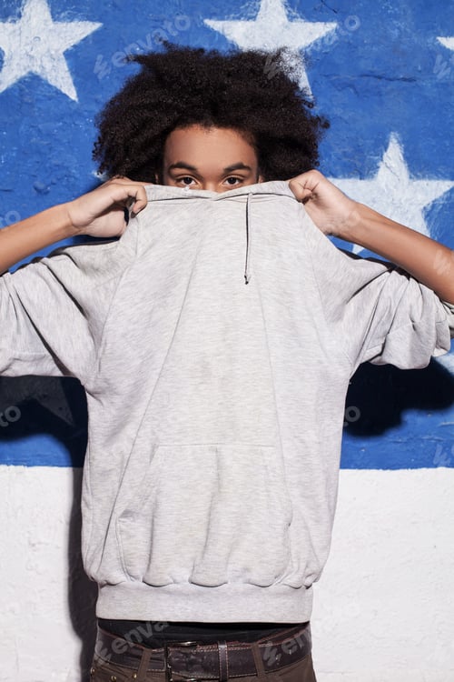 Preview: Cool and young. Young African man hiding his face in his clothing