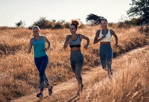 Preview: Group of sporty female friends running outdoors.
