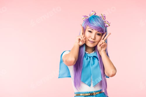 Preview: Pretty asian anime girl in purple wig showing peace signs isolated on pink