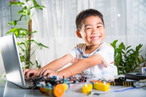 Preview: Asian kid boy learns coding and programming with laptop for Arduino robot car