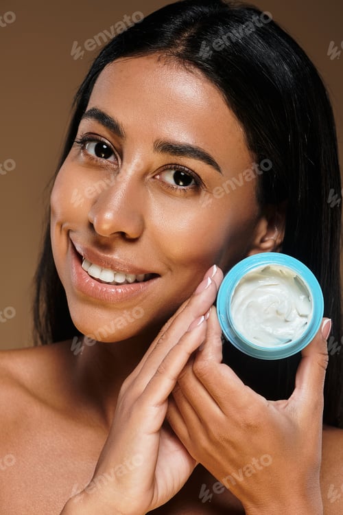 Preview: Beautiful African American woman showcasing body care in studio for skincare routine