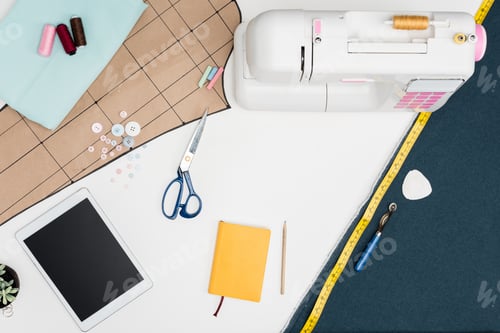 Preview: flat lay with digital tablet with blank screen, sewing machine, cutting sheet and other tailoring