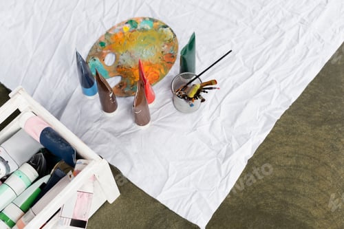 Preview: Top view of paints and palette on white cloth on floor