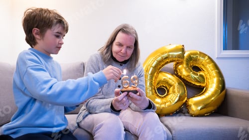 Preview: Grandson helping grandmother lighting 69 birthday candles