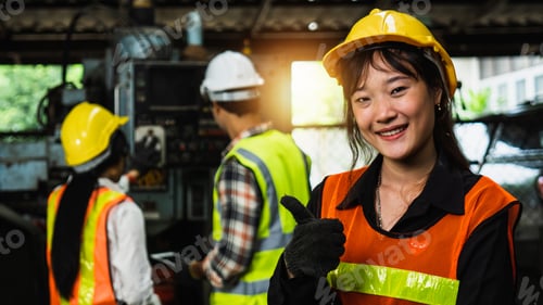 Preview: portrait of worker show thumb up in industry with team working background in factory
