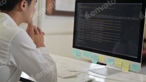 Preview: Programmer checks the code on a computer with a stressful expression.