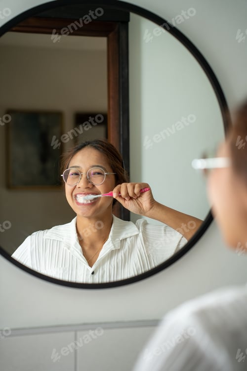 Preview: morning brushing teeth. Young woman brushing teeth with toothbrush and looking