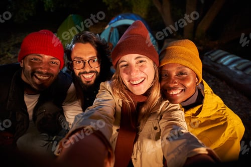 Preview: Photo of men and women smiling and taking selfie in camping forest.