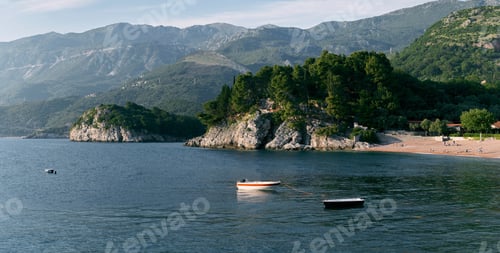 Preview: Fishing boats sway on the waves near the rocky shore overgrown with green forest