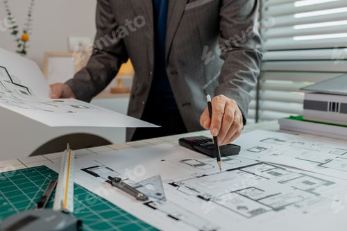 Preview: An architect is working in the office, there are blueprint and house model on the desk, engineer is