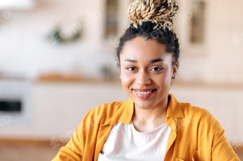 Preview: Smiling Woman Wearing a Yellow Shirt Inside a Home