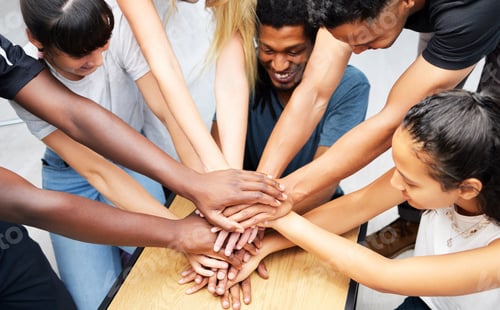 Preview: Shot of a group of coworkers huddling their hands together in a team sprit huddle
