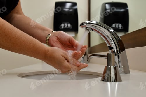 Preview: Washing hands in a public restroom, bathroom. Stop the spread of germs, sickness, colds and illness.