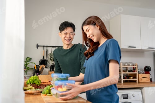 Preview: Asian young new marriage couple spend time together in kitchen at home.