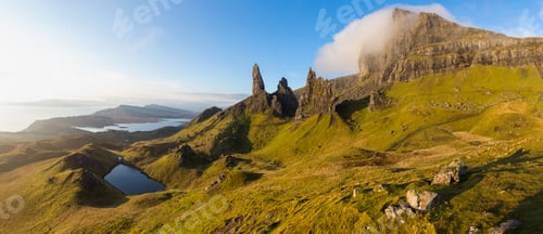 Preview: Mountainous landscape with rocks and lake, ocean in the distance.