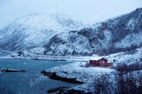 Preview: Single house perched on a snowy beach with a rugged coastline in the background.