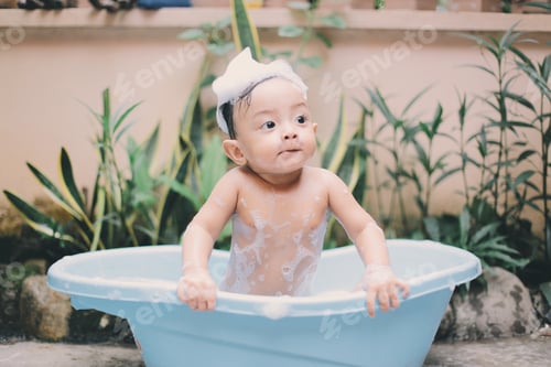 Preview: Baby taking a bath in blue tub