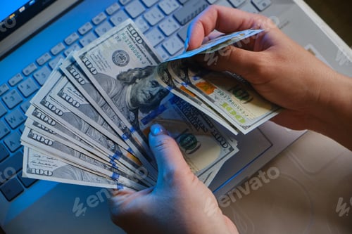 Preview: female hands holding fan of money hundred dollars banknotes