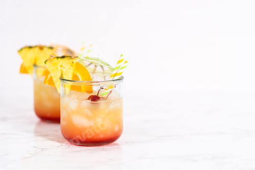 Tropical Alcoholic Drinks Garnished with Pineapple and Orange