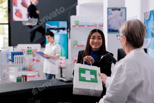 Preview: Elderly pharmacist giving medicaments paper bag to smiling buyer
