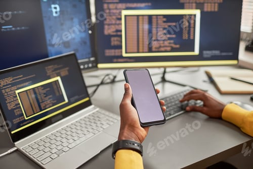 Preview: Close up of unrecognizable black man holding smartphone and writing code