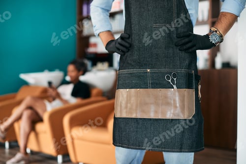 Preview: Unrecognizable hair salon owner with a customer in the background.