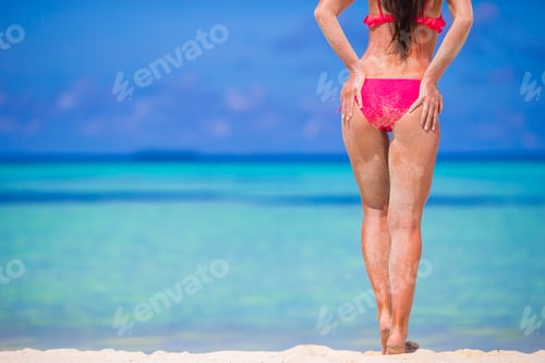 Preview: Sexy back of beautiful woman in red bikini on sea background