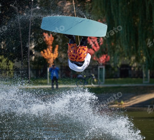 Preview: Young surfer having fun wakeboarding in the cable park.