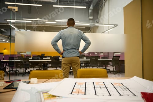 Preview: Male manager standing in office while putting hands on hips