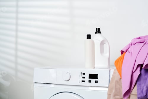 Preview: White Washing Machines With Colorful Clothes in a Laundry Room