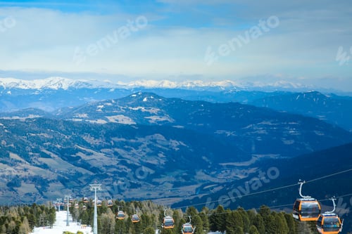 Vorschau: Orangefarbene Gondelkabinen der Seilbahn auf winterlichen schneebedeckten Bergen, Hintergrund, wunderschöne Landschaft