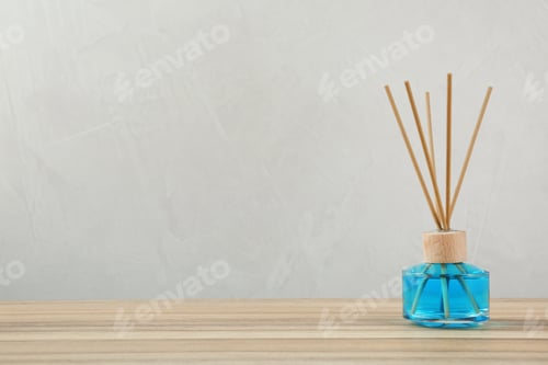 Preview: Reed air freshener on wooden table against grey background, space for text