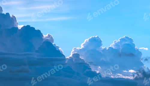 Preview: Dramatic light and dark cumulonimbus and cumulus clouds in blue sky background at evening time