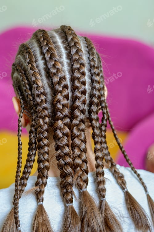 Preview: The girl demonstrates her hairstyle with afro-braids. Rear view. Vertical view. Selective focus.