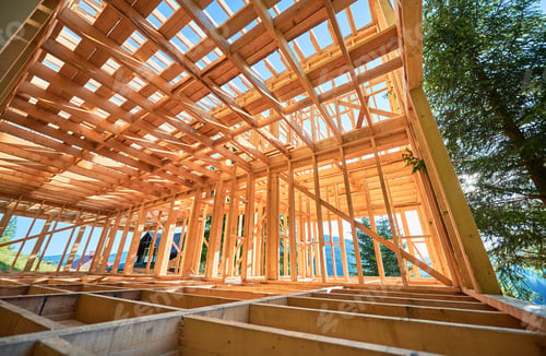 Preview: Wooden frame house under construction near forest.