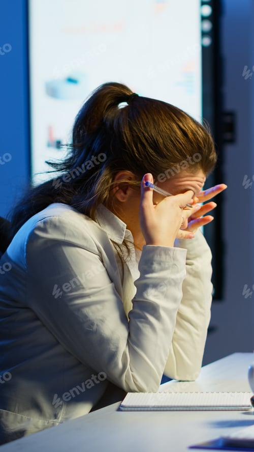 Preview: Focused entrepreneur checking graphics from laptop writing on notebook