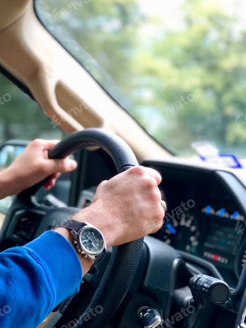 Preview: Mans hands on steering wheel driving on road trip