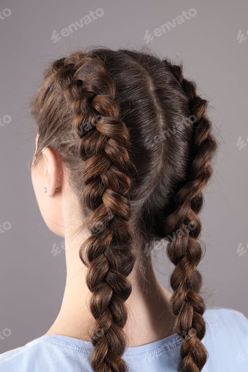 Preview: Woman with braided hair on grey background, back view