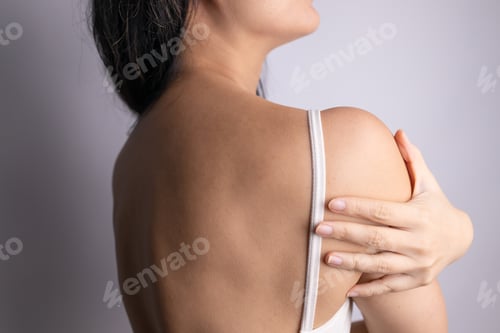 Preview: Closeup shot of woman from back having neck or shoulder pain. Injury or muscle spasm. Back and spine