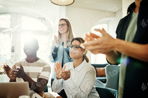 Preview: Diverse group of smiling colleagues clapping during an office presentation