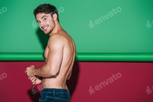 Preview: shirtless, sexy man smiling at camera on green and red background