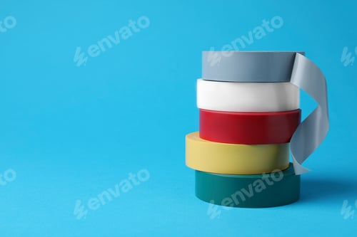 Preview: Colorful insulating tapes on light blue background. Space for text