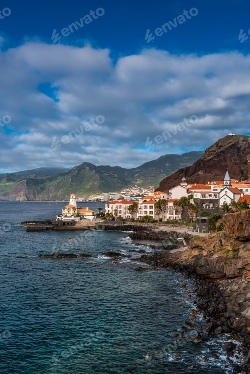 Preview: Marina da Quinta Grande, Madeira, Portugal. Seaside small village with lighthouse on rocky cliffs.