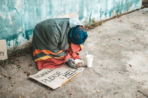 Beggars sitting on the street with homeless messages please help.