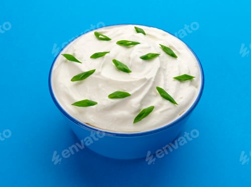 Preview: Bowl of sour cream on blue background