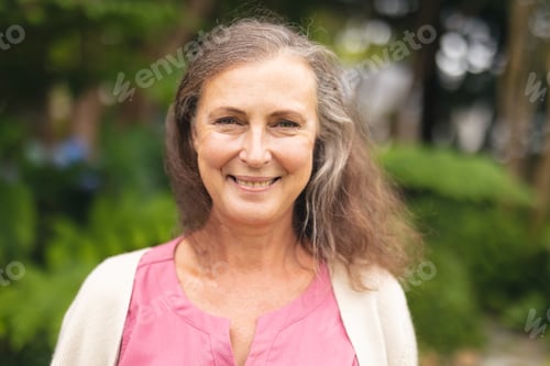 Preview: Portrait of smiling caucasian senior woman standing in backyard on weekend