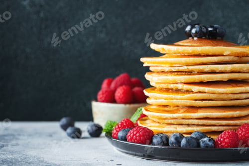 Preview: Delicious pancakes, with fresh blueberries, raspberry and maple syrup or honey on a dark background